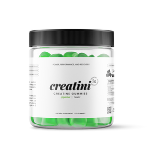 Creatine gummies container next to a green cocktail with green apple slices garnishing on a white background