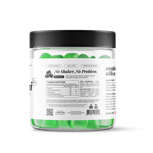Creatine gummies container next to a green cocktail with green apple slices garnishing on a white background