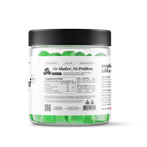 Creatine gummies container next to a green cocktail with green apple slices garnishing on a white background